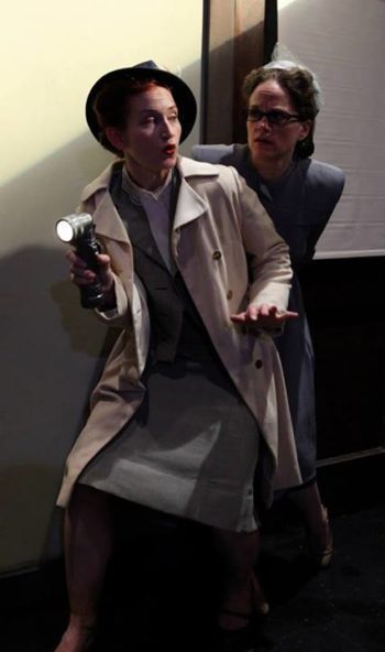 BO THOMAS_Megan Schemmel_Kelly Yacono_photo by Johnny Knight Two 1950s noir-dressed women sneak into a dark room with a flashlight