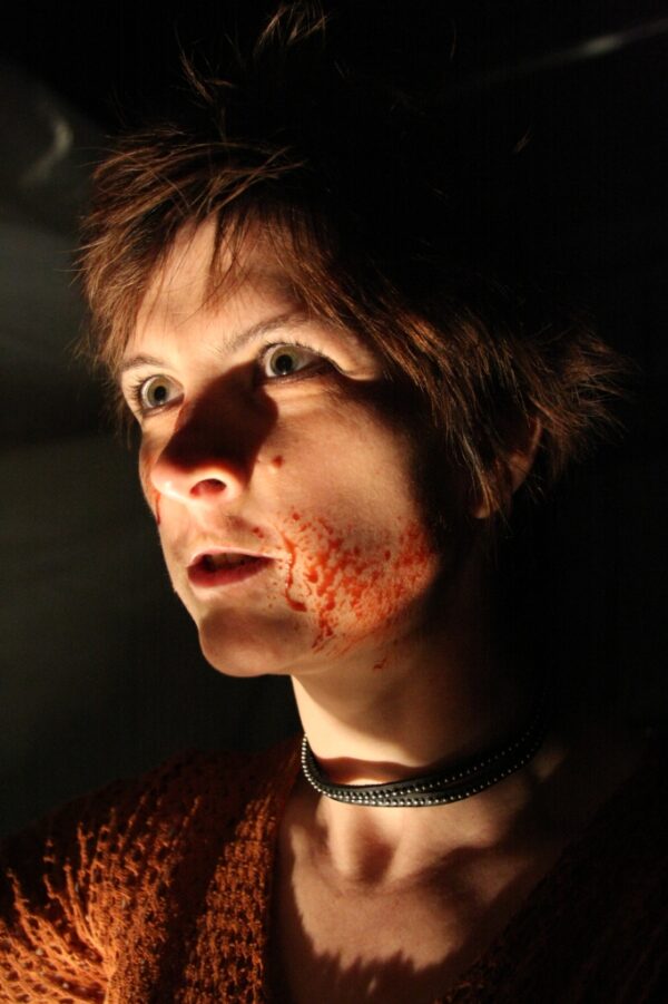 A warrior woman seething with splattered blood on her face