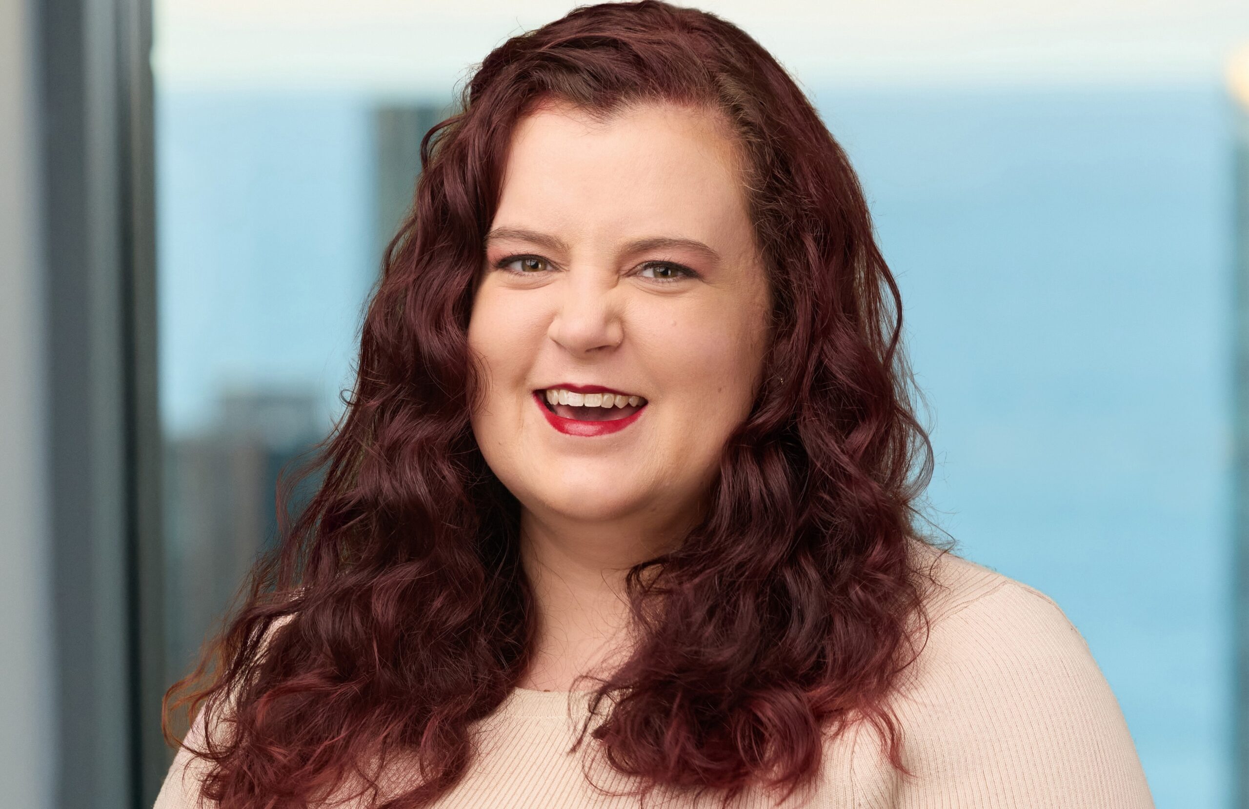 Woman smiling with long, red and curly hair